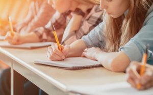 Students in class taking notes about a subject matter